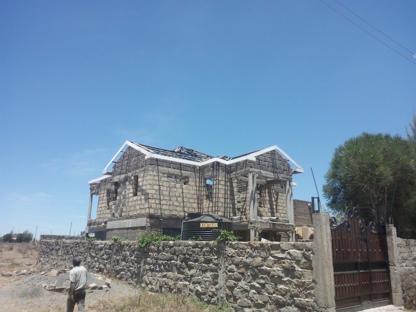 Large two-storey stone residence with roof structure under construction