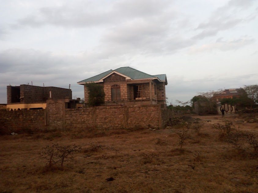 Completed bungalow with green iron-sheet roof